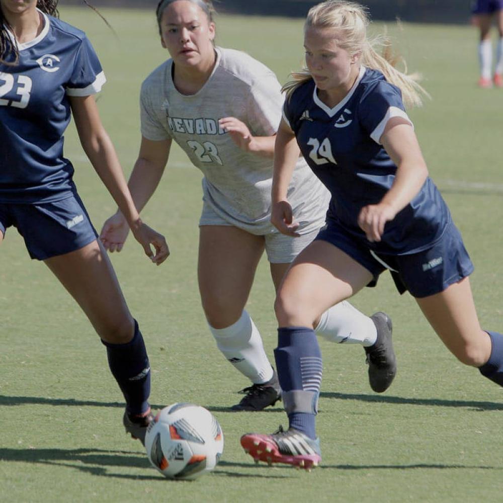 A women's soccer player competing on the pitch